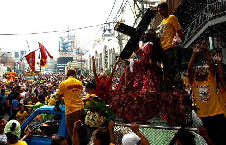 Devotees are sprinkled with holy water during a procession of Black Nazarene replicas two days before the annual procession of the Black Nazarene in Manila, Philippines January 7, 2016.