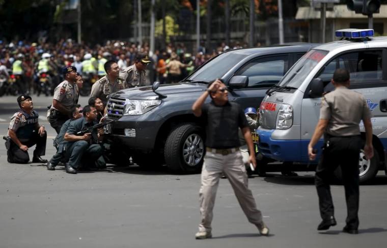 Police officers react near the site of a blast in Jakarta, Indonesia, January 14, 2016. Several explosions went off and gunfire broke out in the center of the Indonesian capital on Thursday and police said they suspected a suicide bomber was responsible for at least one the blasts.