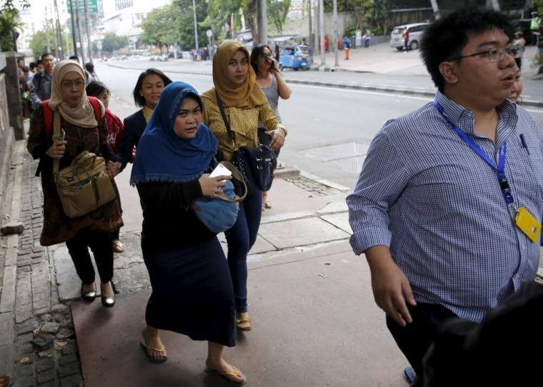 Indonesian workers run as they are evacuated from their office at Thamrin business district in Jakarta, January 14, 2016. Several explosions went off and gunfire broke out in the center of the Indonesian capital on Thursday and police said they suspected a suicide bomber was responsible for at least one the blasts.