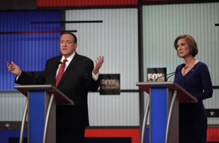 Former Arkansas Governor Mike Huckabee speaks as former HP CEO Carly Fiorina listens during a forum for lower polling candidates at the Fox Business Network Republican presidential candidates debate in North Charleston, South Carolina January 14, 2016.