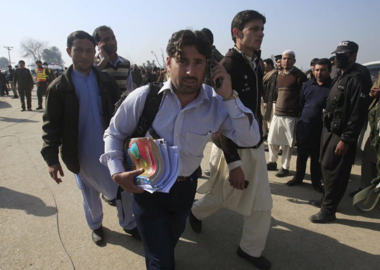 A student holding his books talks on a mobile phone, after he was rescued in a militant attack at Bacha Khan University in Charsadda, Pakistan, January 20, 2016.