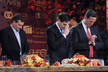 Republican U.S. presidential candidates Ted Cruz, Marco Rubio, and Rick Santorum pray at the Presidential Family Forum in Des Moines, Iowa November 20, 2015.