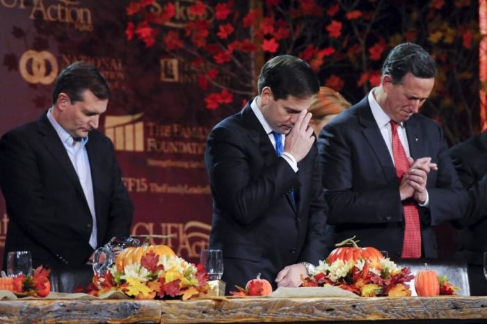 Republican U.S. presidential candidates Ted Cruz, Marco Rubio, and Rick Santorum pray at the Presidential Family Forum in Des Moines, Iowa November 20, 2015.