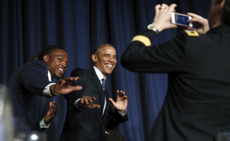 U.S. President Barack Obama and college football Heisman Trophy winner Derrick Henry assume the position of the famous trophy after Obama spoke at the National Prayer Breakfast in Washington February 4, 2016.