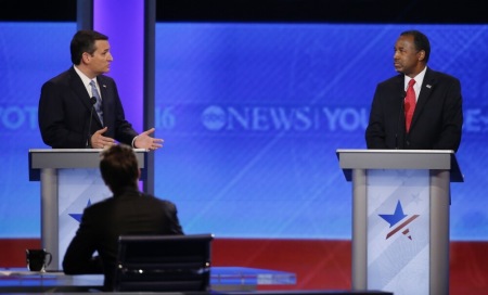 Republican U.S. presidential candidate and U.S. Senator Ted Cruz (L) and Dr. Ben Carson discuss events between their campaigns and the actions of Cruz campaign staff on the night of the Iowa caucus as they debate during the Republican U.S. presidential candidates debate sponsored by ABC News at Saint Anselm College in Manchester, New Hampshire February 6, 2016.