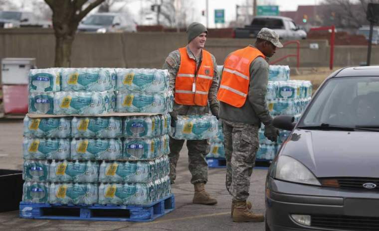 Michigan National Guardsmen distribute bottled water to Flint residents at a fire station in Flint, Michigan February 7, 2016.