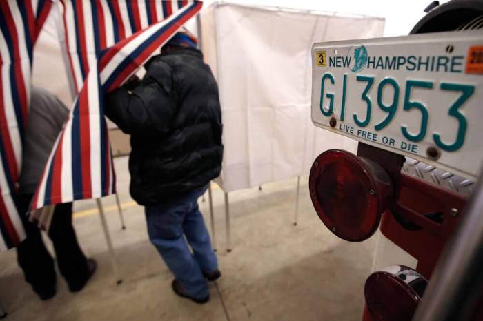 A voter enters a voting booth in the U.S. presidential primary election at the Stark Volunteer Fire Department in the village of Stark, New Hampshire, February 9, 2016.