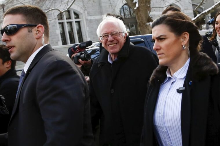 Democratic U.S. presidential candidate Bernie Sanders smiles as he walks along a street near a polling place in Concord, New Hampshire, February 9, 2016.