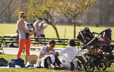 Mothers relax on the grass with their babies at Central Park during a warm day in New York, March 22, 2012.