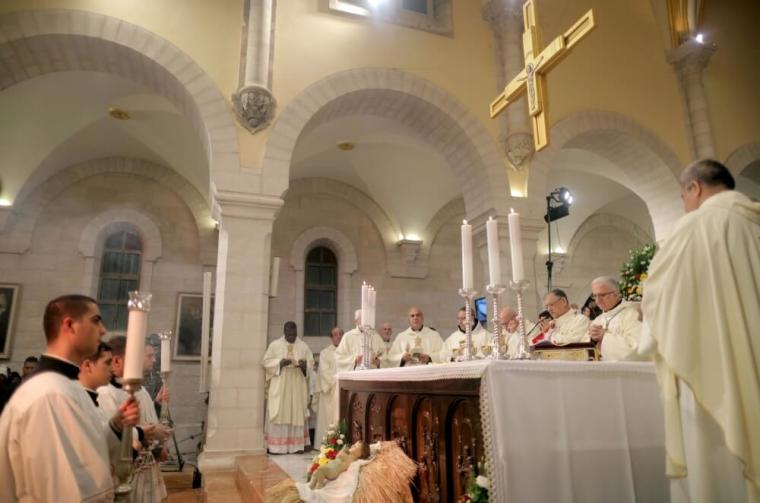 Latin Patriarch of Jerusalem Fouad Twal (3rd R) leads a Christmas midnight mass at the Church of the Nativity in the West Bank town of Bethlehem, December 25, 2015.