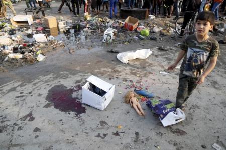 A boy walks at the site of suicide blasts in Baghdad's Sadr City February 28, 2016. The death toll from two suicide blasts in Baghdad's mainly Shi'ite district of Sadr City rose to 24 with more than 60 others wounded, police and medical sources said on Sunday.