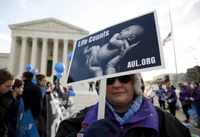 A protester holds up a sign in front of the U.S. Supreme Court in Washington March 2, 2016.