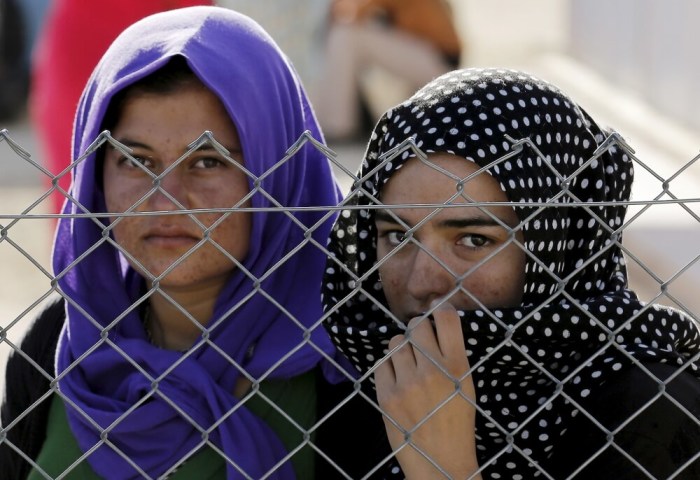 Yazidi refugees stand behind fences as they wait for the arrival of United Nations High Commissioner for Refugees Special Envoy Angelina Jolie at a Syrian and Iraqi refugee camp in the southern Turkish town of Midyat in Mardin province, Turkey, June 20, 2015.