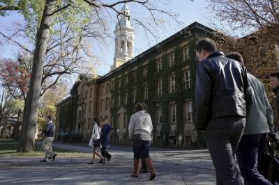 People walk past Princeton University's Nassau Hall in Princeton, New Jersey, November 20, 2015.