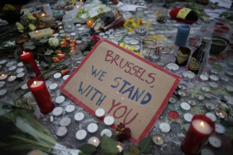 Candles are seen near a message, 'Brussels, We Stand With You', at a street memorial at the Place de la Bourse to victims of Tuesdays's bomb attack in Brussels, Belgium, March 24, 2016.