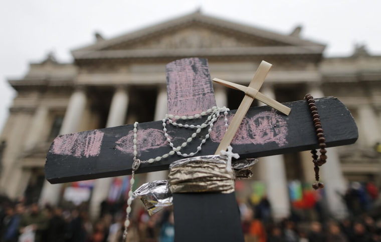 A cross is seen in front of the old stock exchange building at a street memorial to victims of Tuesday's bombings in Brussels, Belgium, March 24, 2016.