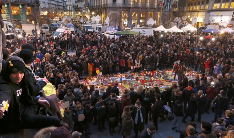 People attend a street memorial service near the old stock exchange in Brussels following Tuesday's bomb attacks in Brussels, Belgium, March 23, 2016.