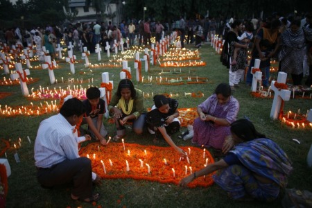 A Christian family gather beside the grave of their relatives at the cemetery of Holy Rosary church during All Souls' Day in Dhaka, Bangladesh, November 2, 2009.