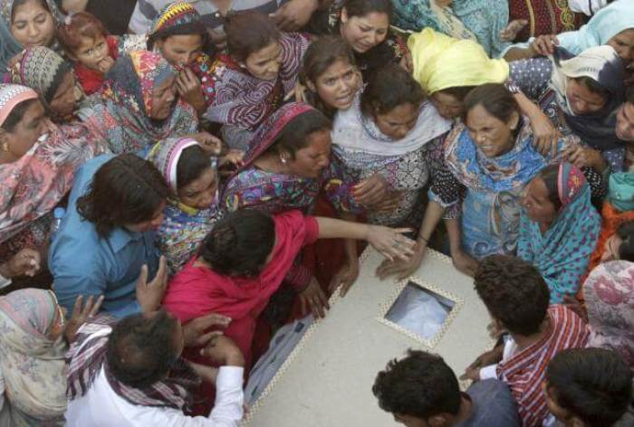 Family members mourn as they gather near the body of a relative, who was killed in a blast outside a public park on Sunday, during funeral in Lahore, Pakistan, March 28, 2016.