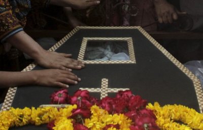 Family members touch a coffin of a relative, who was killed in a blast outside a public park on Sunday, during a funeral in Lahore, Pakistan, March 28, 2016.