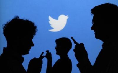 Credit : FILE PHOTO: People holding mobile phones are silhouetted against a backdrop projected with the Twitter logo in this illustration picture taken in Warsaw September 27, 2013.