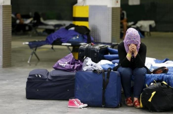 A Syrian woman cries as she sits on a folding bed in a former newspaper printing house used as a refugee registration centre for the German state of Hesse in Neu-Isenburg, on the outskirts of Frankfurt, Germany, September 11, 2015.