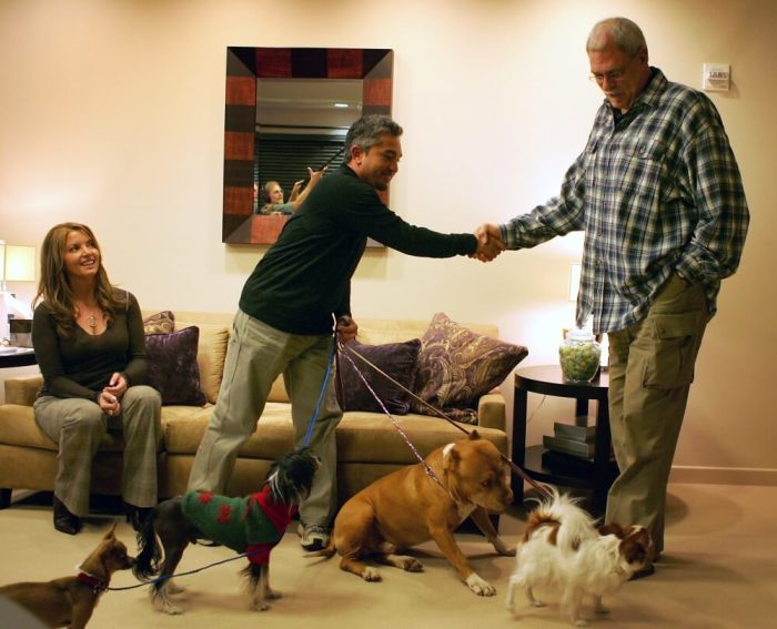 Los Angeles Lakers head coach Phil Jackson (R) is greeted by 'Dog Whisperer' Cesar Millan as Lakers Executive Vice President Jeanie Buss (L) watches on at the Toyota Training Center in Los Angeles December 30, 2005. Millan was there doing a show with Buss's dog, Princess.