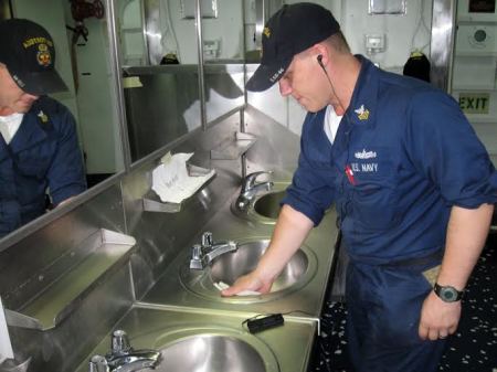 A United States Navy sailor cleaning a sink while listening to the Military BibleStick in this undated photo.