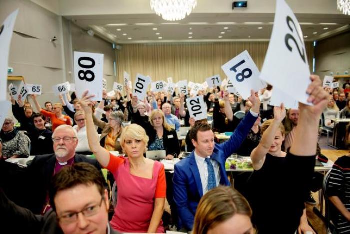 Norwegian Church Council leader Kristin Gunleiksrud Raaum (in red) and Chairman of the Oslo diocesan council Gard Sandaker-Nielsen (R) vote on a proposal to allow same-sex marriage within the Norwegian Church, in Oslo, Norway April 11, 2016.