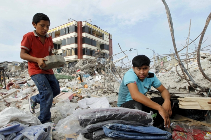 People look through debris as rescue efforts continue on to a fourth day in Pedernales, Ecuador, after an earthquake struck off Ecuador's Pacific coast, April 20, 2016.