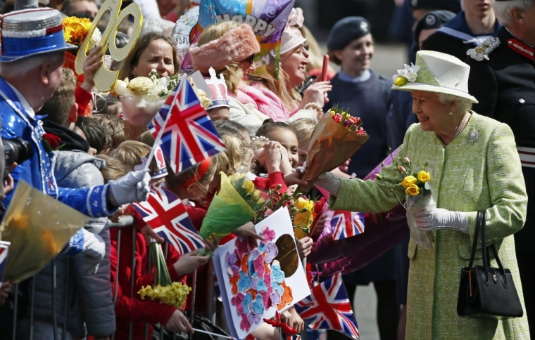 Britain's Queen Elizabeth receives flowers and cards from well-wishers during a walk-about to celebrate her 90th birthday, in Windsor, Britain April 21, 2016.