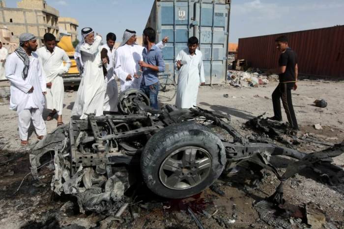 Civilians gather at the site of a car bomb attack in Samawa, south of Baghdad, May 1, 2016.