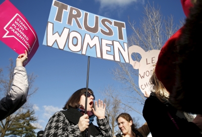 Protesters hold signs in front of the U.S. Supreme Court, in Washington March 2, 2016.