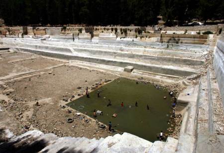 Palestinian boys collect fish in ancient Solomon's Pools near West Bank town of Bethlehem July 2, 2005. Solomon's Pools were built during King Herod's reign. They provided water to both Bethlehem and Jerusalem from ancient times until very recently. The three pools are each over 100 m (328 feet) long and 10 m (32 feet) deep and have a combined capacity of nearly 300,000 cubic meters of water.