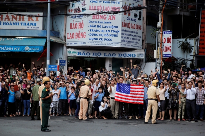 Local residents holds a U.S. flag as U.S. President Barack Obama arrives at Ho Chi Minh City, Vietnam, May 24, 2016.