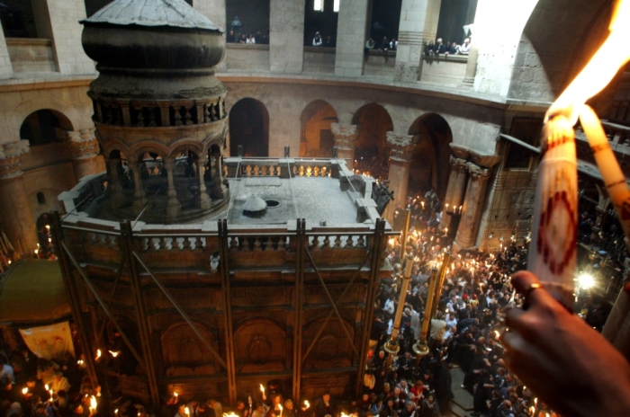 Christian-Orthodox worshippers perform the Holy Fire ceremony on April 26, 2003 inside the Church of the Holy Sepulchre in Jerusalem's Old City which Christian faithful believe is built on the site of Jesus'last resting place after his body was removed from the cross. The fire is first taken from inside the tomb and then rapidly spreads throughout the ancient church as faithful light each other's candles.