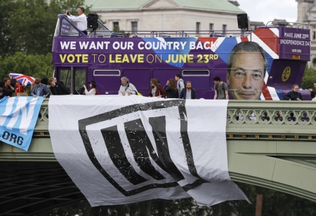 A Vote Leave campaign bus is driven past Remain campaigners hanging a large banner from Werstminster Bridge as they try to disrupt a flotilla of fishing vessels campaigning to leave the European Union as it sails up to Parliament on the river Thames in London.