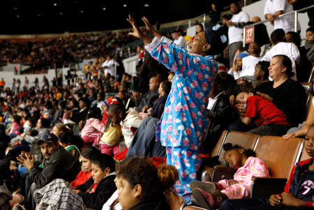 Carolyn Anderson cheers while sitting with her four children as they await gifts during The Dream Center Christmas in the City event in Los Angeles, California, December 20, 2009. Thousands of bicycles and toys were given away to families in need during The Dream Center Christmas in the City event. Anderson and her family arrived at 5am to ensure they were one of the families to receive the gifts