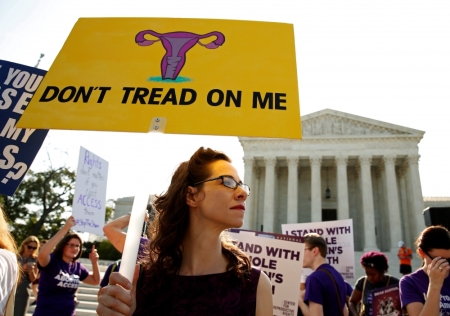 Demonstrators hold signs outside the U.S. Supreme Court.