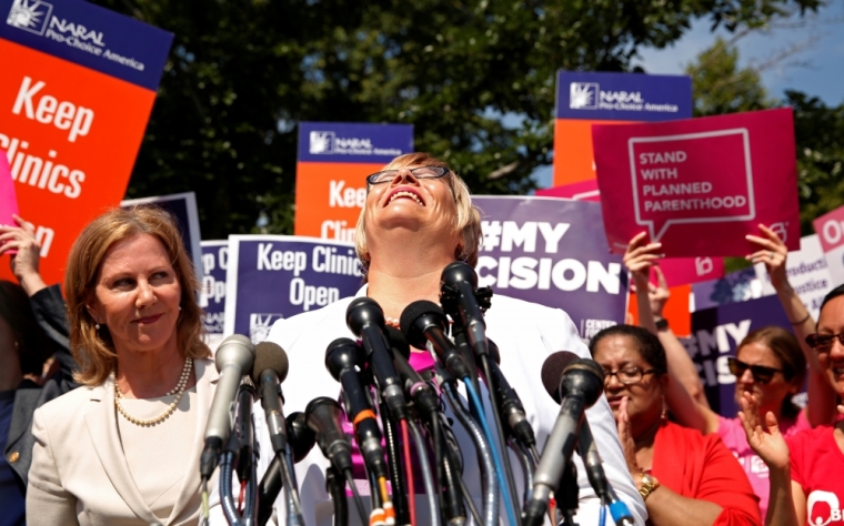 Lead plaintiff Amy Hagstrom-Miller, president and CEO of Whole Woman's Health abortion group, looks skyward as she arrives to speak outside the U.S. Supreme Court after the court handed a victory to abortion providers, striking down a Texas law that required clinics to increase health and safety standards for women, Washington June 27, 2016. At left is Nancy Northup, president and chief executive of the Center for Reproductive Rights.