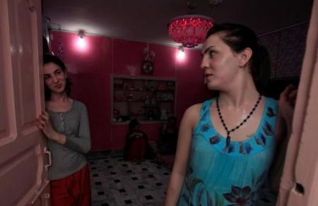 Transgenders Sunny (L) and Maria chat at the front door of their home in Peshawar, Pakistan June 27, 2016.