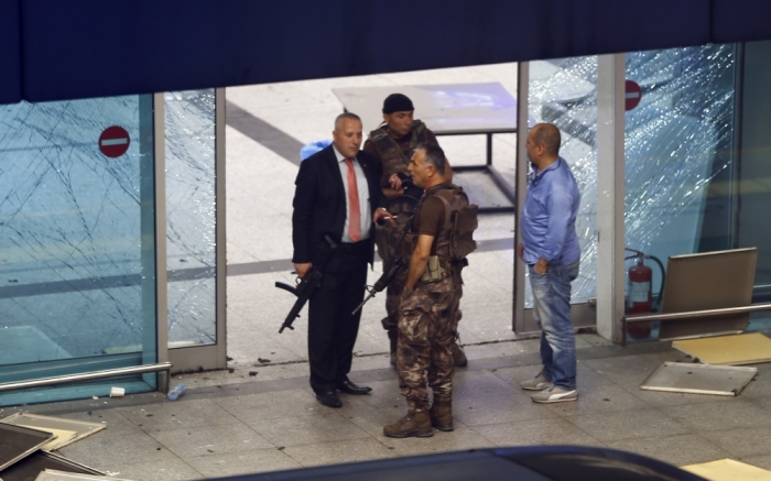 Armed security stand at an entrance of Turkey's largest airport, Istanbul Ataturk, Turkey, following a blast June 28, 2016.