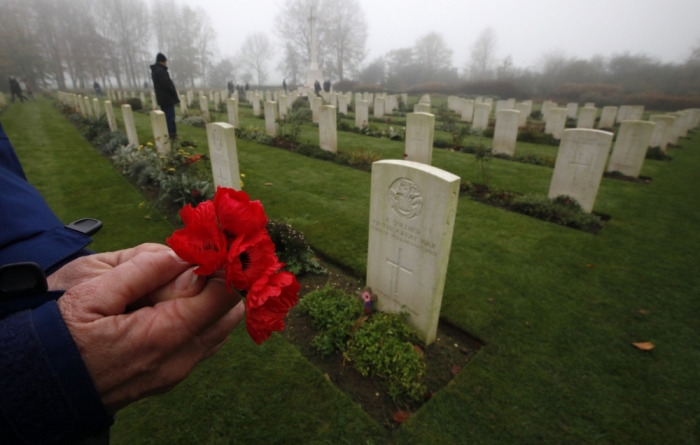 A visitor holds a bunch of poppies during Armistice Day commemorations at the Franco-British National Memorial in Thiepval near Albert, northern France, November 11, 2011 .The memorial was built to remember some 73,000 soldiers from the Commonwealth missing after the battle of Somme during World War One.