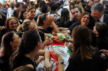 Women mourn over the coffin of Joseph Laous, who died after a suicide bomb attack in his village, during his funeral in Qaa, Lebanon, June 29, 2016.