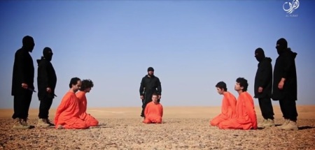 Islamic State militants stand behind accused spies in a publicized beheading video that was filmed in the Syrian desert and posted to pro-IS media outlets on June 28, 2016.