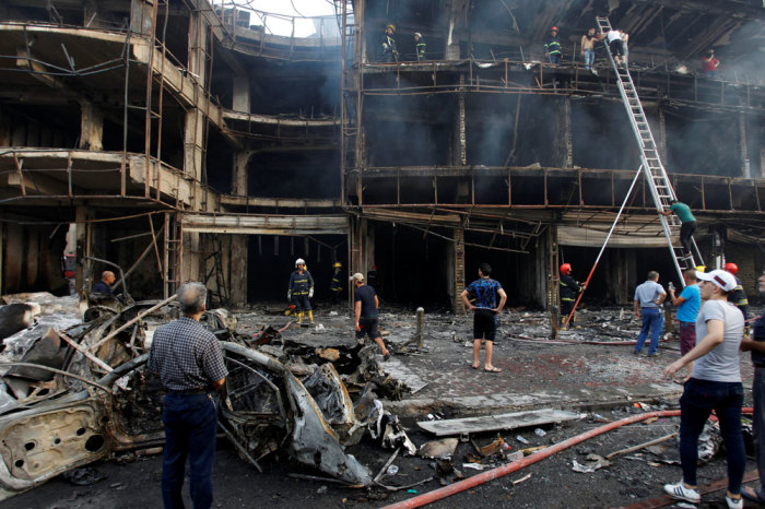 People gather at the site of a suicide car bomb in the Karrada shopping area, in Baghdad, Iraq July 3, 2016.