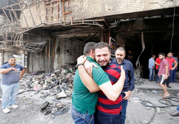 Iraqi men react at the site after a suicide car bomb attack at the shopping area of Karrada, a largely Shi'ite district, in Baghdad, Iraq July 4, 2016.