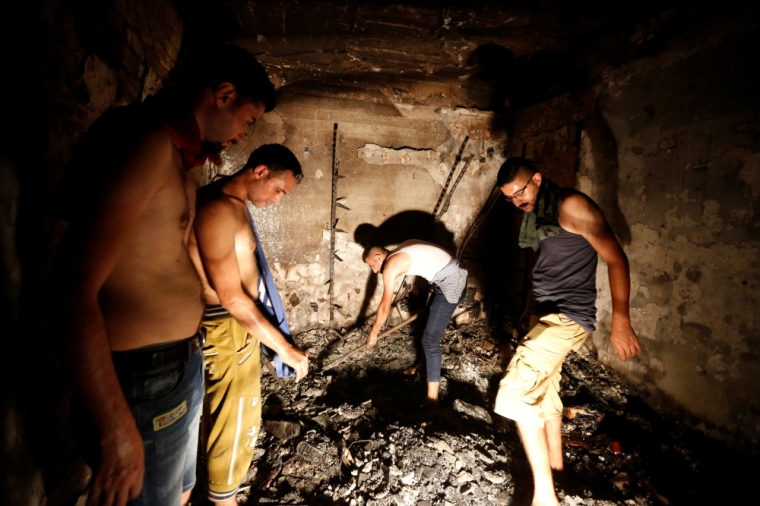 People search for their relatives at a site after a suicide bomb attack at the shopping area of Karrada, a largely Shi'ite district, in Baghdad, Iraq, July 4, 2016.