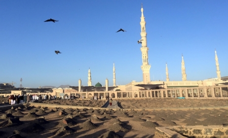 Muslim worshippers visit 'Al-Baqi' cemetary, where the Prophet Mohammad's family, relatives and companions are buried, with Al-Masjid al-Nabawi, (the Mosque of the Prophet) seen in the background, after the early morning prayer of Al-Fajr in the holy city of Medina, Saudi Arabia January 20, 2016.