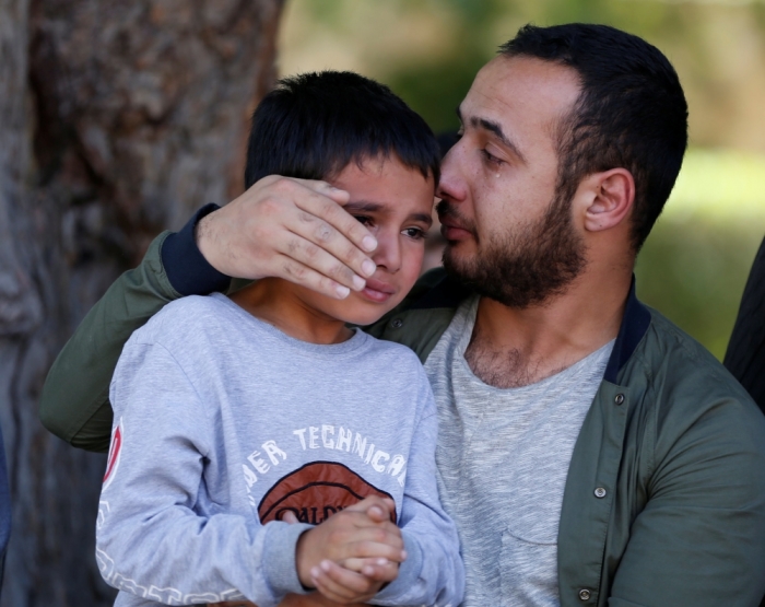 The son of Zabihullah Tamanna (L), an Afghan journalist, and his brother-in-law cry as Tamanna's coffin is transferred onto an ambulance at a hospital in Kabul, Afghanistan, June 7, 2016.